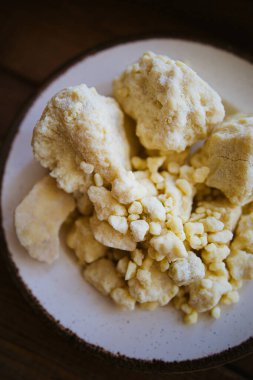 Büyük ve küçük kakao yağı parçaları. Beyaz bir tabakta ezilmiş çikolata. Beyaz çikolata rengi üst görünüm. çikolatalı makro fotoğraf