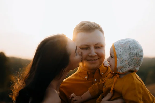 幸福家庭的肖像 妻子亲吻她丈夫的脸颊 快乐的父亲把女儿抱在怀里 父亲节和家庭日 — 图库照片