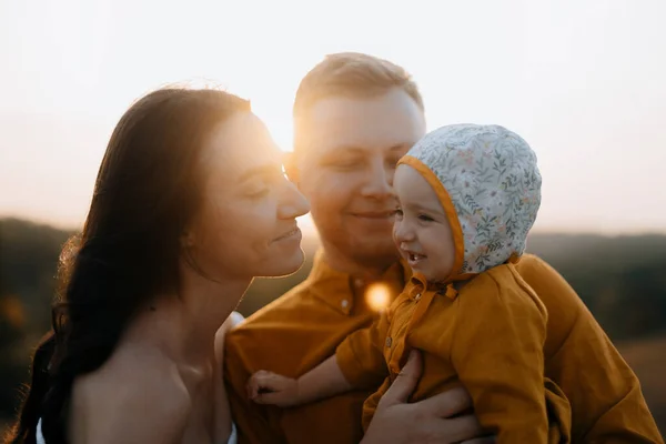 一个带着孩子的快乐的年轻家庭的肖像 日落时有孩子的女人和男人 幸福的家庭的脸庞被阳光照亮了 — 图库照片
