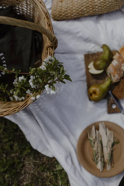 Keranjang Wicker Pada Selimut Piknik Putih Keranjang Jerami Dengan Cabang — Stok Foto
