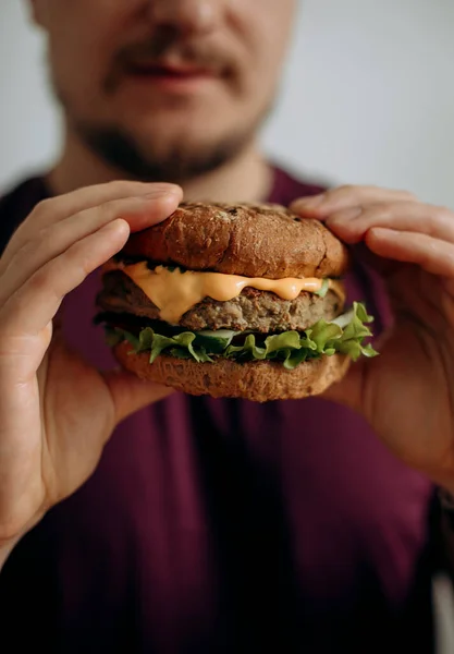 Burger Tangan Seorang Pria Muda Berjanggut Seorang Pria Lapar Memegang — Stok Foto