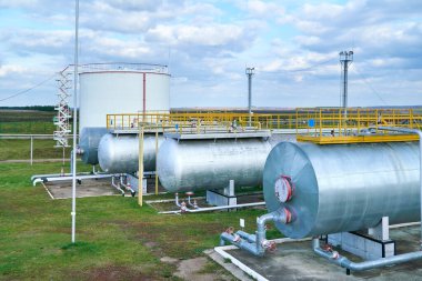 Bulutlu bir günde petrol konteynırları tarlada duruyor