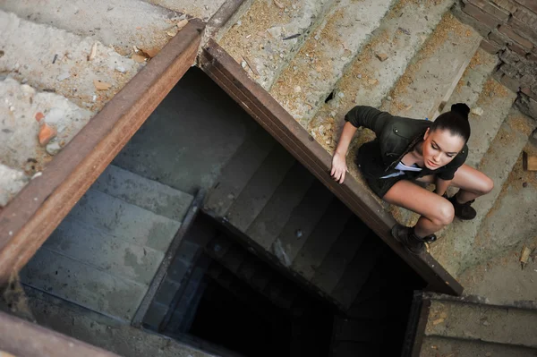 Mädchen in der Nähe der Ziegelmauer im militärischen Stil. Lara Kate Stil. — Stockfoto