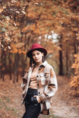 Sonbaharda parkta duran zarif bir kadın.