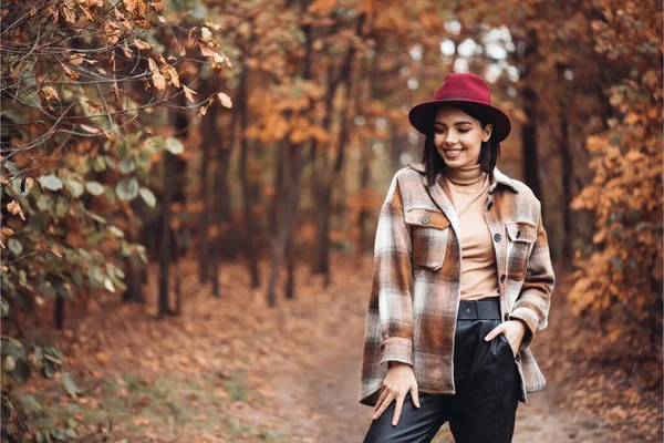 Sonbahar gününde güzel bir kadın. Güzellik ve moda. Sonbahar modası ve yaşam tarzı. Sıcak sonbahar kıyafetleri, şapka ve sarı eşarp giyen güzel bir kadın. Sonbahar havası. Açık havada şık bir kadın..