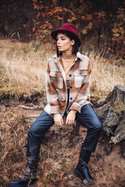 Sonbahar gününde güzel bir kadın. Güzellik ve moda. Sonbahar modası ve yaşam tarzı. Sıcak sonbahar kıyafetleri, şapka ve sarı eşarp giyen güzel bir kadın. Sonbahar havası. Açık havada şık bir kadın..