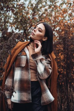 Sonbahar gününde güzel bir kadın. Güzellik ve moda. Sonbahar modası ve yaşam tarzı. Sıcak sonbahar kıyafetleri, şapka ve sarı eşarp giyen güzel bir kadın. Sonbahar havası. Açık havada şık bir kadın..