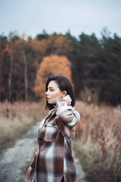 乾燥した秋の森の中でファッショナブルな服を着た若い女性 — ストック写真