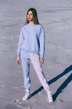 Kum tepeciğinde yürüyen moda kadını portresi