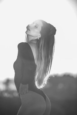 Siyah plaj kıyafeti giyen, kumsaldaki şık sarışın kadın.