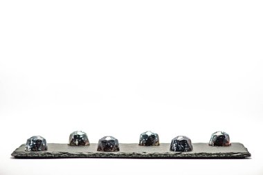 Tatil, düğün, doğum günü, yıldönümü için yazarın tatlıları. Stüdyoda beyaz arka planda siyah şekerler..