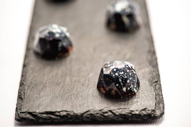 Tatil, düğün, doğum günü, yıldönümü için yazarın tatlıları. Stüdyoda beyaz arka planda siyah şekerler..