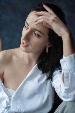 Ev ortamında genç bir kadın günlük giysiler giyiyor.