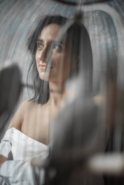 Kafeste bir kuşla evde bir kadın