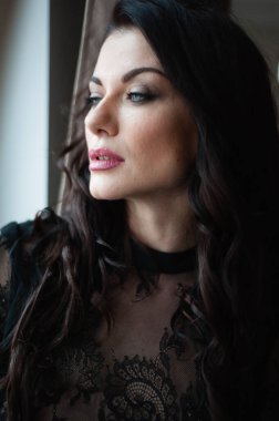 Uzun siyah elbiseli, şehvetli, esmer kadın..