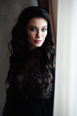 Uzun siyah elbiseli, şehvetli, esmer kadın..