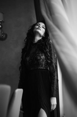 Uzun siyah elbiseli, şehvetli, esmer kadın..