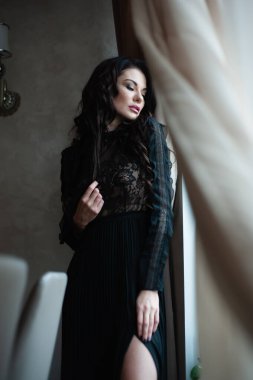 Uzun siyah elbiseli, şehvetli, esmer kadın..