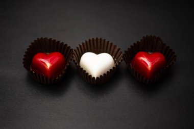 Siyah arka planda çikolatalı kalpler