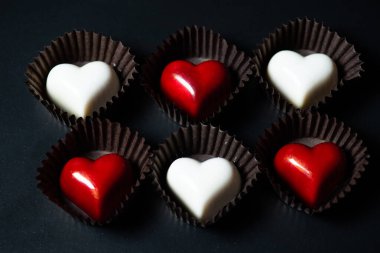 kalp şeklinde çikolata şekerlemeleri siyah arkaplanda