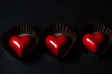 Siyah arka planda çikolatalı kalpler