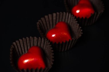 Siyah arka planda çikolata kalpli şeker.