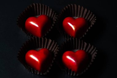 kalp şeklinde çikolata şekerlemeleri siyah arkaplanda