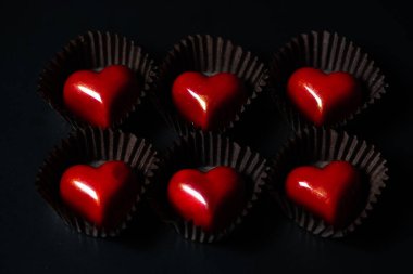 Siyah arka planda çikolatalı kalpler