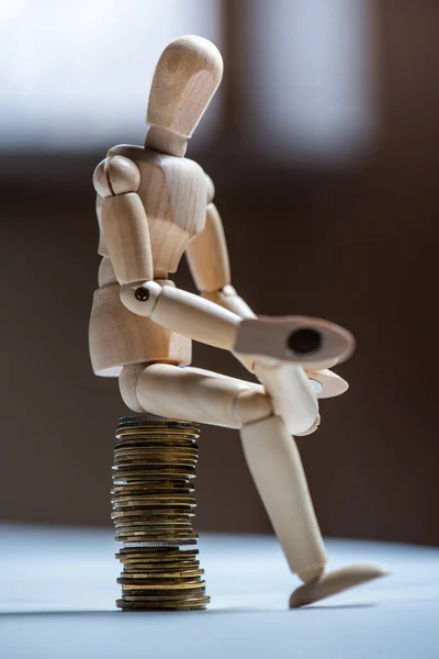 Wooden man toy figure with money on white background. Business concept.