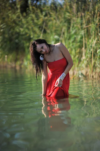 赤いドレスで砂の上で凍る美しい女性のファッション屋外写真 — ストック写真