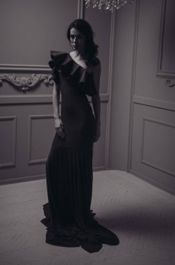 Güzel saç stili ve makyajlı, uzun, siyah bir gece elbisesi içinde güzel bir kadın.