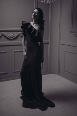 Güzel saç stili ve makyajlı, uzun, siyah bir gece elbisesi içinde güzel bir kadın.