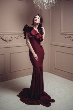 Güzel saç stili ve makyajlı, uzun, siyah bir gece elbisesi içinde güzel bir kadın.