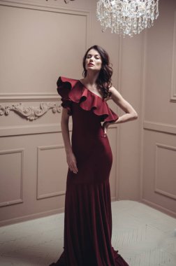 Güzel saç stili ve makyajlı, uzun, siyah bir gece elbisesi içinde güzel bir kadın.