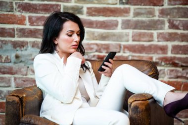 Arka planda resmi beyaz elbiseli, güler yüzlü iş kadını