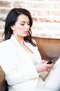 Arka planda resmi beyaz elbiseli, güler yüzlü iş kadını