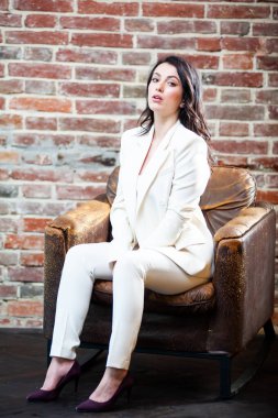 Arka planda resmi beyaz elbiseli, güler yüzlü iş kadını