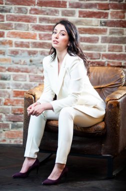 Arka planda resmi beyaz elbiseli, güler yüzlü iş kadını