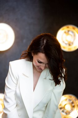 Arka planda resmi beyaz elbiseli, güler yüzlü iş kadını