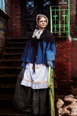 Eski şehirde yürüyen genç bir Victoria kadınının açık hava portresi