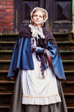 Eski şehirde yürüyen genç bir Victoria kadınının açık hava portresi