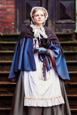 Eski şehirde yürüyen genç bir Victoria kadınının açık hava portresi