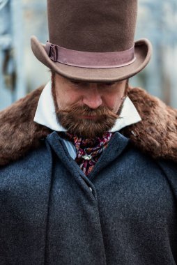 Zarif takım elbiseli ve şapkalı bir adamın portresi, eski moda.