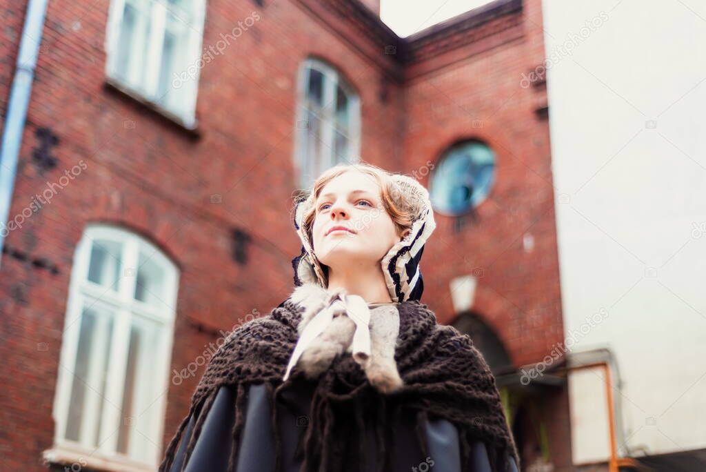 Outdoors portrait of a young victorian woman walking old city