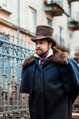 Zarif takım elbiseli ve şapkalı bir adamın portresi, eski moda.