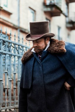 Zarif takım elbiseli ve şapkalı bir adamın portresi, eski moda.