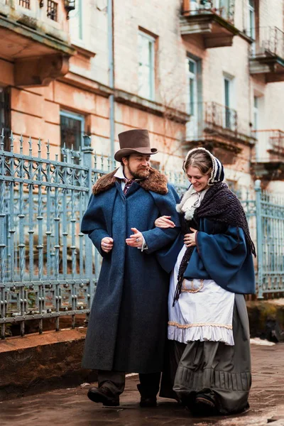 The woman and the man in vintage costumes. People in retro dresses. Walking on the street