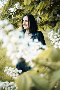 Bir buket çiçekli beyaz elbiseli genç bir kadın.