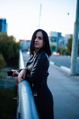 Sokakta poz veren siyah elbiseli güzel bir kadın.