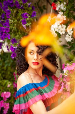 Yaz şehrinde çiçeklerle süslenmiş güzel bir kadın.